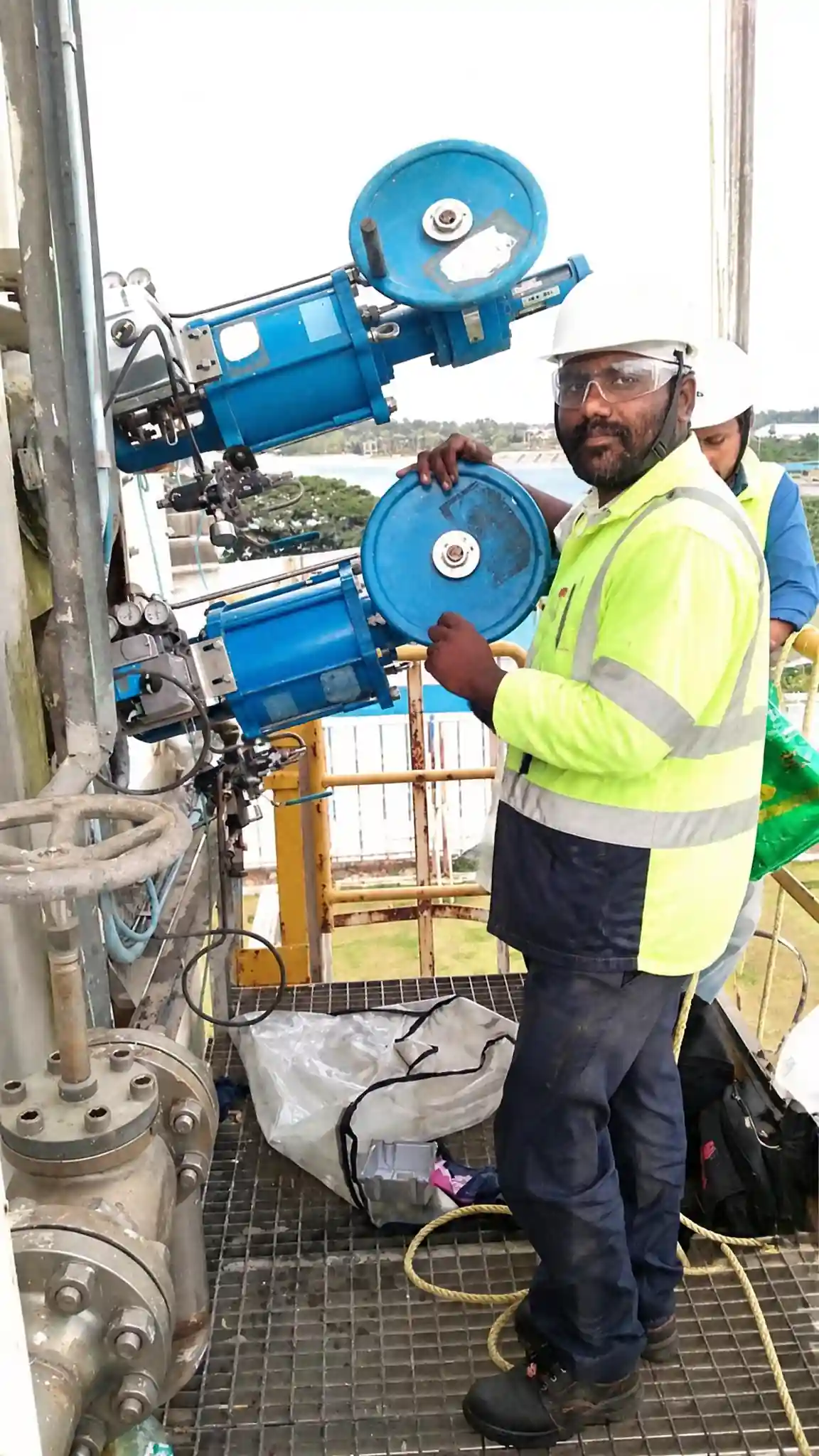 Technician checking handwheel operation on an offshore platform