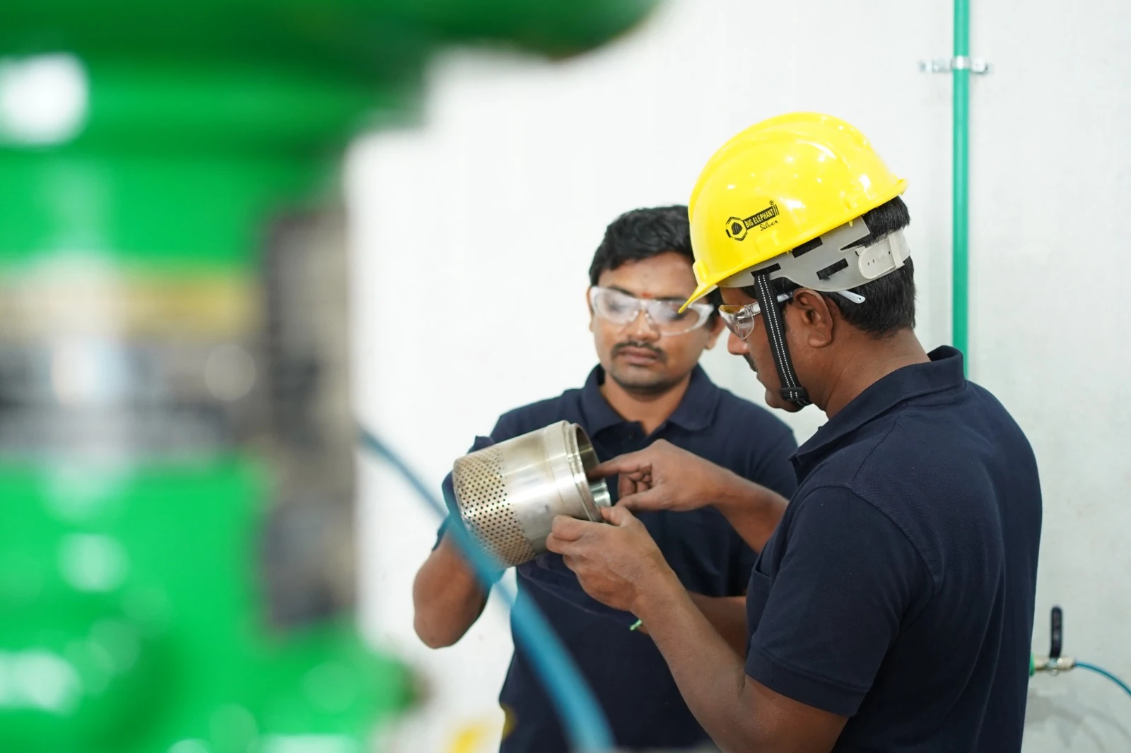Two technicians inspecting a trim component in the refurbishment facility
